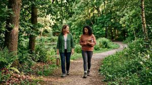 A peaceful outdoor therapy session in a green park, therapist and client walking together among trees